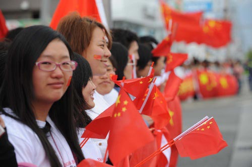 Photo: people waving the National Flag of China hail the flame