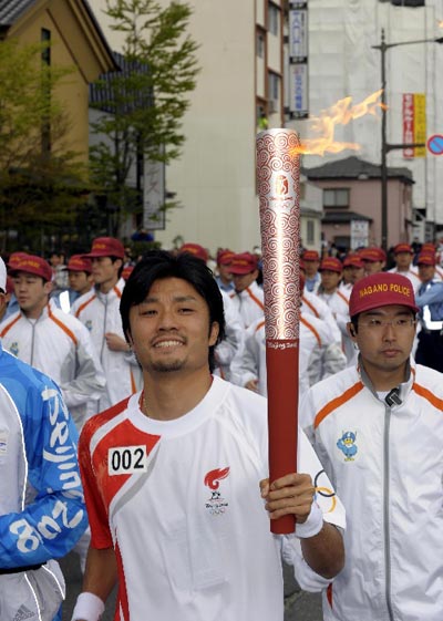 Photo: Torchbearer Shingo Suetsugu runs with Olympic torch