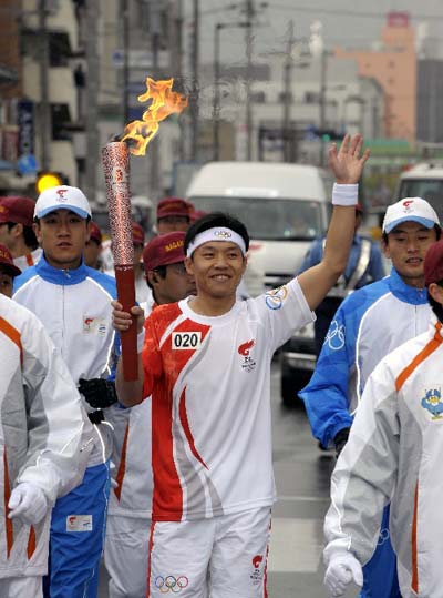 Photo: Chinese student Zhang Bi runs with Olympic torch