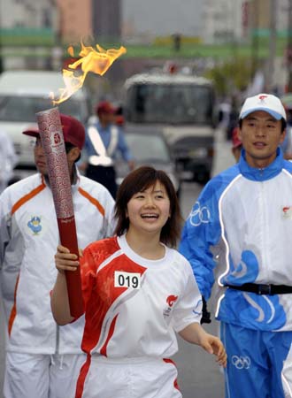Torchbearer Ai Fukuhara, table tennis player, runs with the torch in Nagano, Japan, on April 26, 2008. Nagano is the 16th stop of the 2008 Beijing Olympic Games torch relay. 