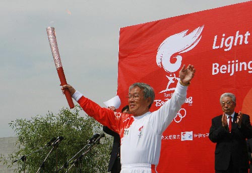 The first runner Park Tu Ik holds the torch. 