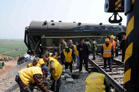 Rescuers work at the site of the trains colliding accident, in east China