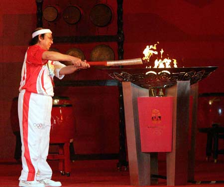 Torchbearer Nguyen Danh Thai, chairman of Vietnam's Olympic Committee, lights the altar during the ceremony after the Olympic torch relay in Ho Chi Minh City, Vietnam，April 29, 2008. Ho Chi Minh City is the 19th leg of the 2008 Beijing Olympic Games torch relay outside the Chinese mainland.(Xinhua Photo)