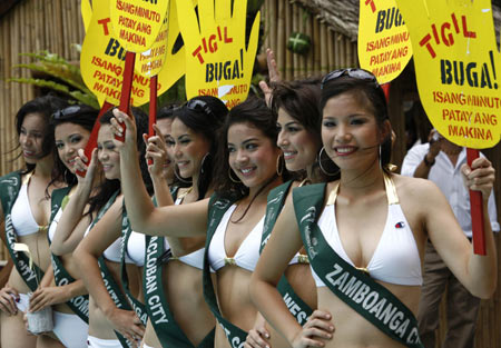 Contestants for the upcoming Miss Philippines Earth 2008 pageant hold signs encouraging motorists to cut emissions as they are presented to the media at a hotel in Manila April 29, 2008. 