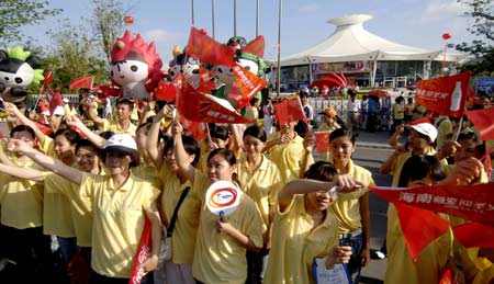 Cheering people wait to watch the 2008 Beijing Olympic Games torch relay in Sanya, south China&apos;s Hainan Province, on May 4, 2008.