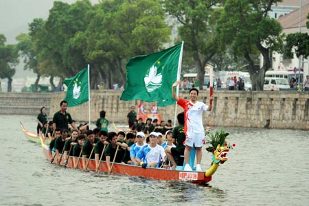 Pang Tsz Shan holds the torch on a boat during the 2008 Beijing Olympic Games torch relay in Macao, south China, on May 3, 2008. (Xinhua/Zhou Wenjie) 