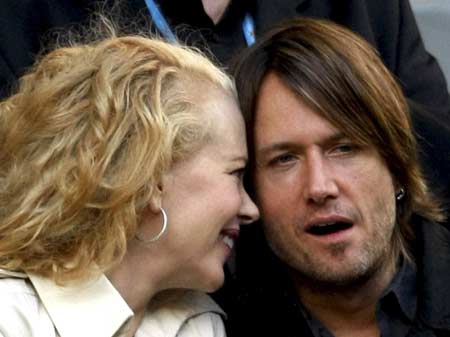 Actress Nicole Kidman (L) and her husband Keith Urban talk to each other as they sit in the stands during the match between Australia's Lleyton Hewitt and Serbia's Novak Djokovic at the Australian Open tennis tournament in Melbourne Jan. 21, 2008.