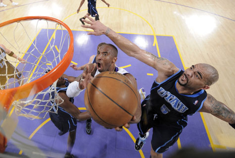 Los Angeles Lakers guard Kobe Bryant (center) puts up a shot as Utah Jazz forward Carlos Boozer (right) guards during the first half of Game 1 of their second round NBA playoff series in Los Angeles on Sunday. The Lakers won 109-98.