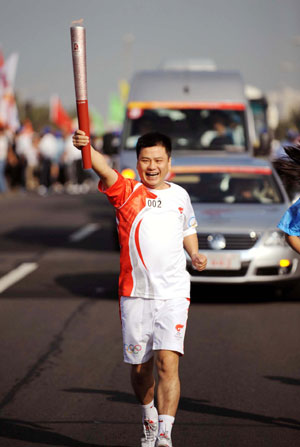 Torchbearer Zhang Zuohong runs with the torch during the 2008 Beijing Olympic Games torch relay in Haikou, south China's Hainan Province, on May 6, 2008.