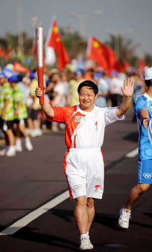 Torchbearer Liu Qingsheng runs with the torch during the 2008 Beijing Olympic Games torch relay in Haikou, south China's Hainan Province, on May 6, 2008.