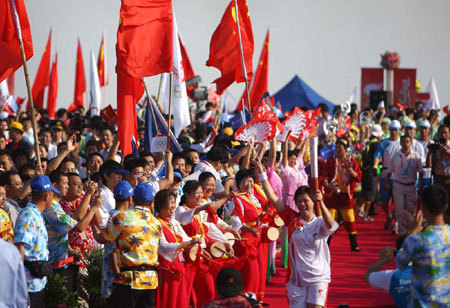 Torchbearer Wang Lifang runs with the torch during the 2008 Beijing Olympic Games torch relay in Haikou, south China's Hainan Province, on May 6, 2008.