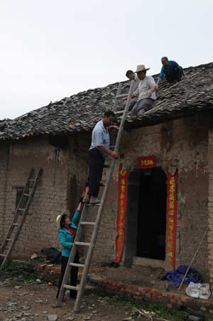 Villagers repair houses damaged in recent rainstorms at Rongyao Village in Dangyang City, central China's Hubei Province, May 4, 2008. Rainstorms, one of the hardest that hit the province since last Friday have left three people dead. (Xinhua/Liu Baoping)