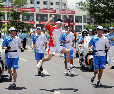 Torchbearer Xiong Ying, an employee of the Haima Automobile of FAW Group, jumps with excitement during the 2008 Beijing Olympic Games torch relay in Haikou, south China's Hainan Province, on May 6, 2008.(Xinhua/Ding Lin)