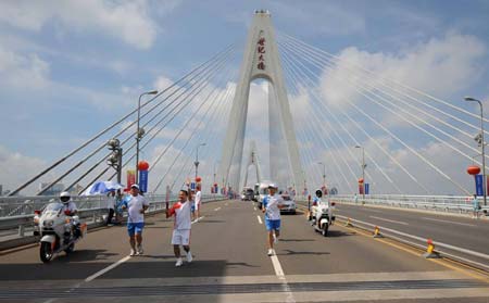 Torchbearer Chen Peng runs with the torch on the Century Bridge during the 2008 Beijing Olympic Games torch relay in Haikou, south China's Hainan Province, on May 6, 2008.