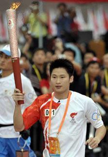 Torchbearer Yang Jinghui runs with the torch during the 2008 Beijing Olympic Games torch relay in the southern Chinese city of Guangzhou Wednesday morning, May 7,2008. (Xinhua Photo)