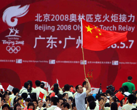 Local residents celebrate during the launching ceremony of the 2008 Beijing Olympic Games torch relay in the southern Chinese city of Guangzhou Wednesday morning, May 7, 2008. 
