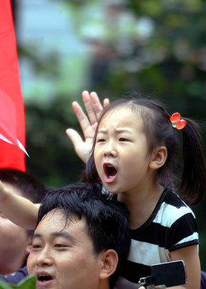 Local residents cheer for the 2008 Beijing Olympic Games torch relay in the southern Chinese city of Guangzhou Wednesday morning, May 7, 2008.