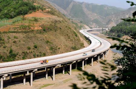 Vehicles of an engineering unit run on a section of the Shanghai-Shaanxi Expressway, northwest China's Shaanxi Province, April 28, 2008. The Shanghai-Shaanxi Expressway with a length of 214.79km and cost of 13.78 billion RMBs will open to traffic by the end of year.