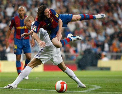 FC Barcelona player Leo Messi is tackled by Real Madrid player Pepe during their Spanish League soccer match at the Santiago Bernabeu stadium in Madrid, yesterday. 