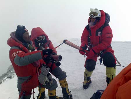 Norbu Zhamdu (L) lights the Olympic torch of the first torchbearer Gegyi with a kindling at the top of the 8844.43-meter summit of Mt. Qomolangma in southwest China's Tibet Autonomous Region on May 8, 2008.