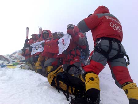 Chinese climbers cheer with flags at the top of the 8844.43-meter summit of Mt. Qomolangma in southwest China's Tibet Autonomous Region on May 8, 2008. 