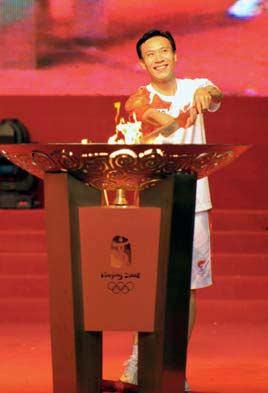 Torchbearer Dong Zhaozhi lights the cauldron with the torch after the 2008 Beijing Olympic Games torch relay in Guangzhou, capital of south China's Guangdong Province, on May 7, 2008.(Xinhua Photo)
