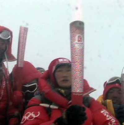 Photo: Last torchbearer Cirenwangmu displays the Beijing Olympic torch