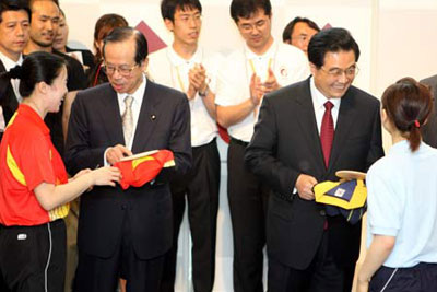 Chinese President Hu Jintao (2nd R) prepares to sign his name on the bat for Japanese table tennis player Ai Fukuhara (R) as Japanese Prime Minister Yasuo Fukuda (2nd L) talks to Chinese table tennis player Wang Nan (L) after the opening ceremony of the 2008 Japan-China youth friendly exchange year at the Waseda University in Tokyo, capital of Japan, May 8, 2008. 