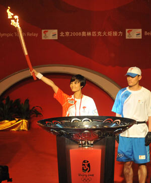 Torchbearer Wang Qihong (L) holds up the torch during a ceremony after the 2008 Beijing Olympic Games torch relay in Shenzhen, south China's Guangdong Province, on May 8, 2008.