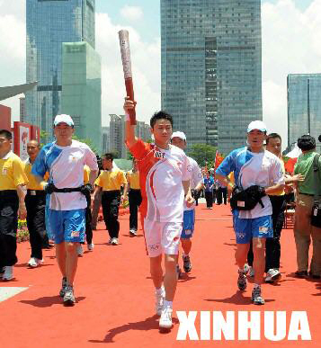 Torchbearer Xiao Junfeng carries the Olympic torch in Shenzhen, southeast China's Guangdong Province on May, 8 2008.