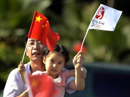 A girl waves flags while watching the 2008 Beijing Olympic Games torch relay in Shenzhen, south China's Guangdong Province, on May 8, 2008.