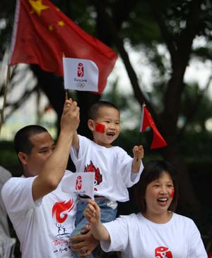 A family of three cheer for the 2008 Beijing Olympic Games torch relay in Huizhou, south China's Guangdong Province, on May 9, 2008.