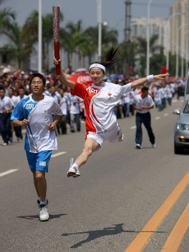 Photo: Torchbearer and artist Lin Shumin dances with the torch
