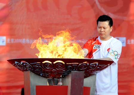 Photo: Retired badminton player Ji Xinpeng lights the cauldron