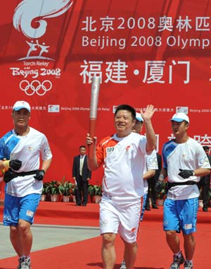 Photo: China's famous table tennis player Guo Yuehua runs with the torch