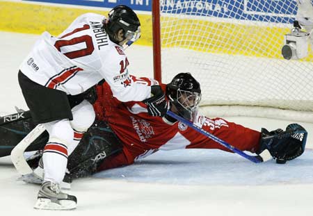 Denmark's goaltender Patrick Galbraith makes a save on Switzerland's Andres Ambuhl (L) during the second period of action at the 2008 IIHF World Hockey Championships in Quebec City, May 11, 2008.