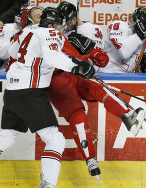  Switzerland's Philippe Furrer (L) hits Denmark's Bo Nordby during the first period of action at the 2008 IIHF World Hockey Championships in Quebec City, May 11, 2008. 