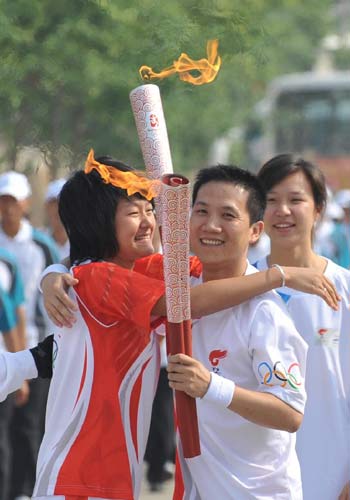 Photo: Torchbearer Tang Zhiyong embraces the next torchbearer Wang Ling