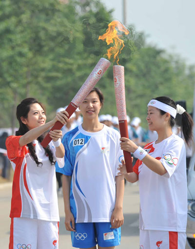 Photo: Torchbearer Chen sisi lights the torch from the previous torchbearer Li Yue