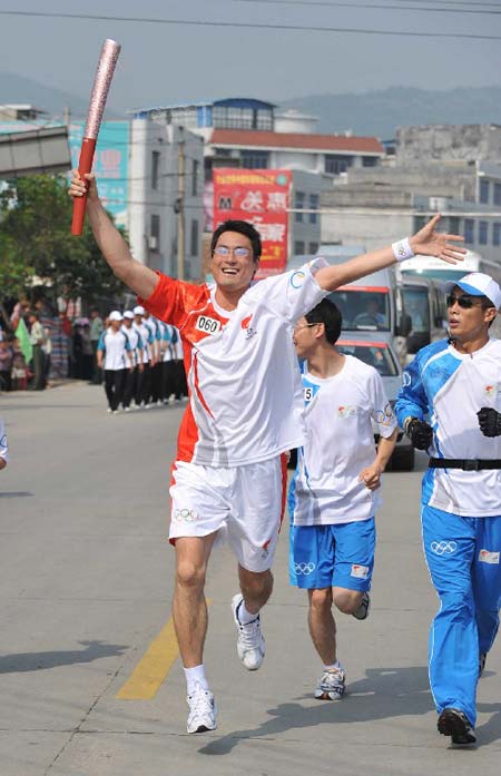 Torchbearer Lin Hua jumps with torch during the torch relay in Longyan