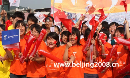 Photo: People cheer for Olympic torch relay