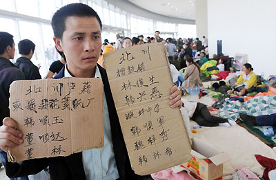 Just returning to his hometown, Yuan Shutong is searching for his relatives and friends at the aid center Jiuzhou Stadium in Mianyang City on May 14, 2008.