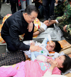 Chinese Premier Wen Jiabao (L) comforts injured children in Yingxiu Town, the quake epicenter in Wenchuan County of southwest China's Sichuan Province, May 14, 2008. 