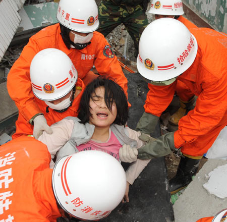 Rescuers from Chongqing Municipality save a survivor in debris of collapsed buildings in Beichuan, one of the counties that suffered the most from Monday's earthquake in southwest China's Sichuan Province, May 14, 2008. 
