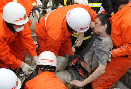 Armed police carry 17-year-old student Yan Peng after he was rescued out of the ruins of a two-story building in the quake-stricken Beichuan County in southwest China's Sichuan Province, May 14, 2008. A strong quake measuring 7.8 on the Richter scale struck Sichuan at 2:28 p.m. on Monday. At that moment, Yan was swung out of classroom by strong shake, but he came back to the classroom, trying to save his trapped classmates. Unfortunately, Yan was buried in the ruins for over 40 hours. Thanks to hard searching and rescuing for several hours by armed police, he was finally saved. 
