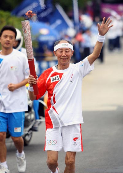 Photo: Torchbearer Zhang Qingyu runs with the torch