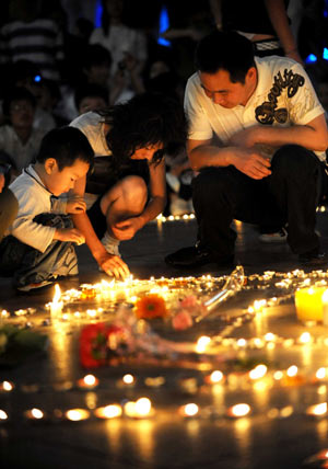 Local residents light candles during a candle vigil of donation activity for the relief to the earthquake tored Sichuan Province in southwest China, in Changsha, capital of central China's Hunan Province, May 15, 2008. 