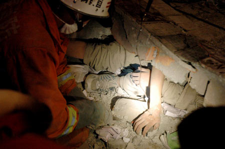 Rescuers clean out the debris pressing on a trapped middle school student Yang Hong in quake-striken Beichuan County, southwest China's Sichuan Province, May 15, 2008. 