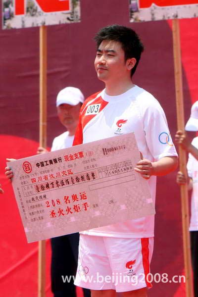 Photo: A torchbearer representative donate money to quake-hit area