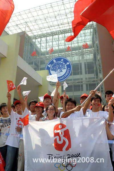 Photo: Local university students welcome the Olympic flame